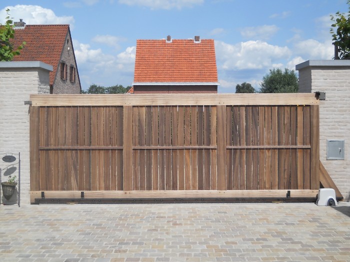 Combineer luxe met gemak met een maatwerk houten schuifpoort Houten schuifpoort schermt een woonerf af.